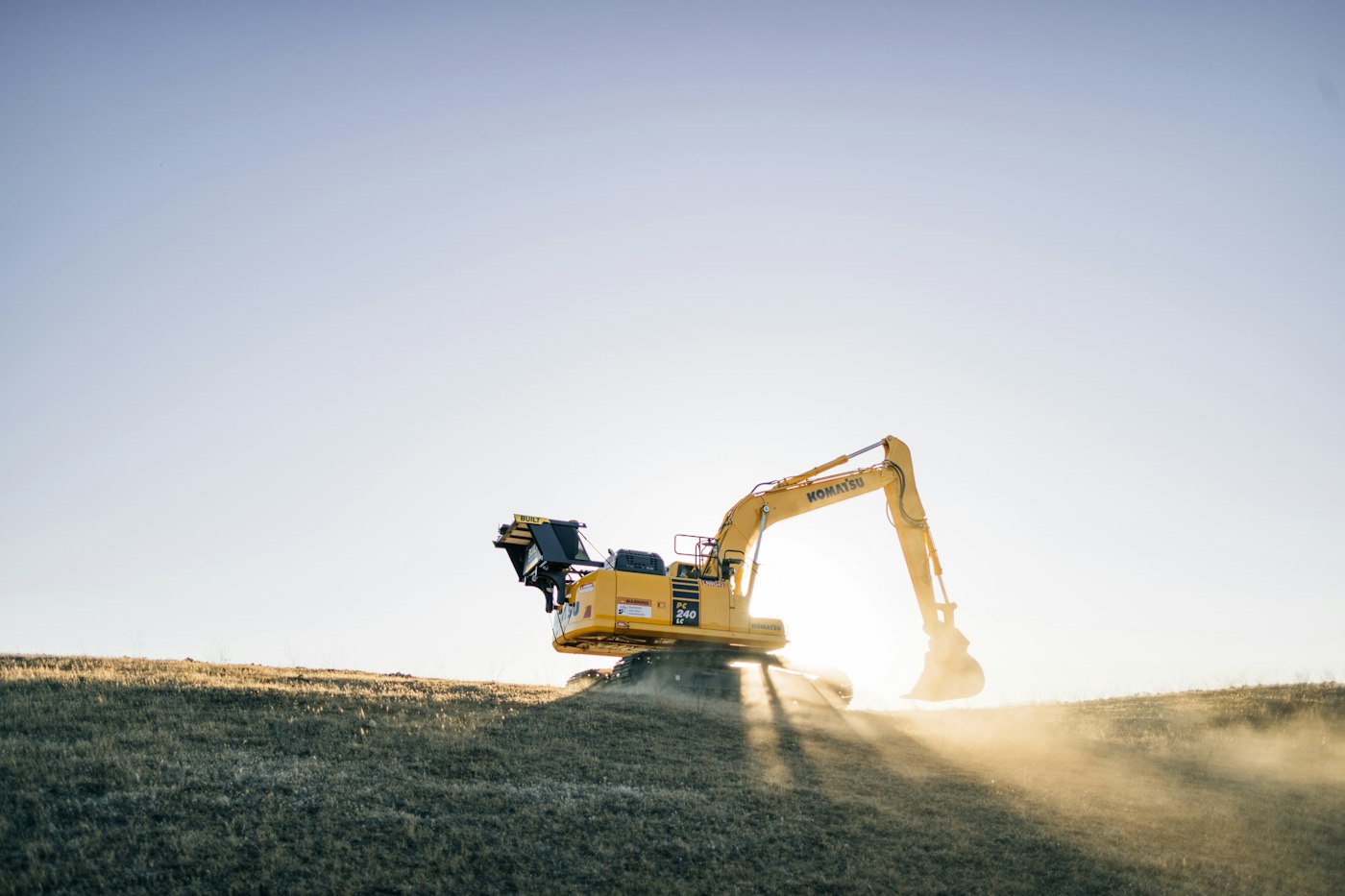 Excavator working on a hillside at dusk