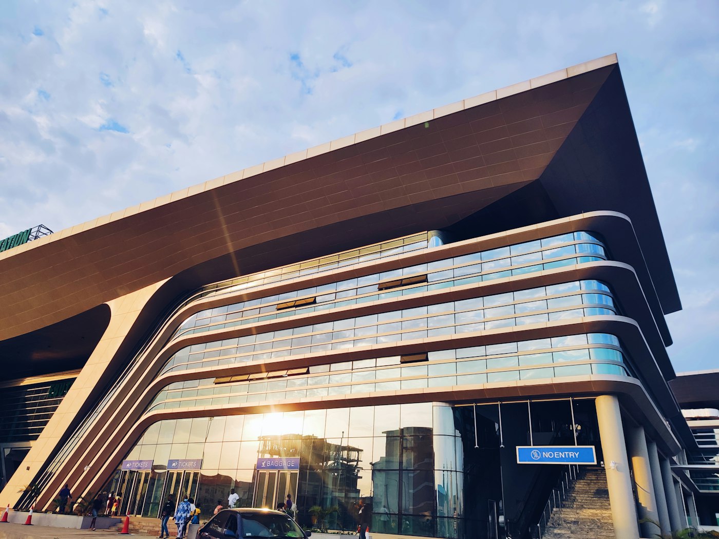 Curved glass and timber-clad facade of a contemporary building in Lagos